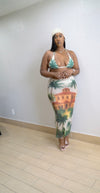 Woman wearing a swimsuit with a palm tree and building print in a room.
